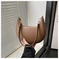 Detail van bruine maanvormige tas met litchi-nerf leer en goudkleurige details - Bruin