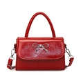 Red glossy patent leather handbag with silver bow detail and adjustable shoulder strap - Red
