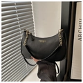 Detalle del bolso de luna en cuero granulado negro con doble cadena dorada y correa de piel - Negro