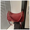 Detalle de bolso media luna rojo con piel de grano lichi y correa de cadena dorada - Rojo