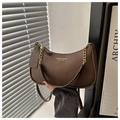 Detalle de bolso de hombro en cuero granulado con logo dorado y cadena metálica - café