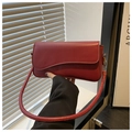 Detail of reddish-brown leather bag with wave flap and thick round shoulder strap - Red