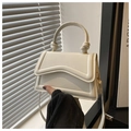 Detalle de la solapa ondulada y el asa anudada del bolso bandolera blanco crema - Blanco