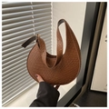 Macro detail of brown crocodile embossed moon bag with golden buckle on adjustable strap - Brown