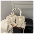 Detail of hand-woven straw bag with floral embroidery and metallic star ornament - White