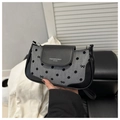 Detailed view of polka dot underarm bag featuring leather texture and bow patterns - Black