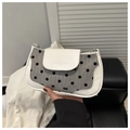 Detail of polka dot fabric underarm bag with leather trim and decorative bow - White