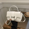 Borsa a tracolla minimalista in pelle bianca con fibbia in metallo in un ambiente domestico - Bianco