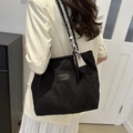 Large black textured tote bag with rope handles and printed silk scarf on a model - Black