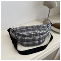 Detail of black and white plaid chest bag with adjustable strap on a minimal background - Green