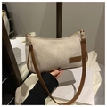 Détail de la texture sergé beige et logo en cuir sur un sac bandoulière vintage épuré - Kaki