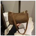 Détail du sac baguette tressé marron avec bandoulière en cuir et étiquette tendance - Marron