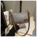 Détail de la texture tissée grise et de la bandoulière en cuir marron du sac minimaliste - Gris