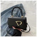 Dettaglio della borsa a mano in pelle nera opaca con elegante fibbia a D dorata - Nero