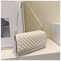 Beige quilted leather crossbody bag with chain strap on a white minimalist pedestal - White