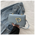 Dettaglio borsa a tracolla azzurra con fibbia a D dorata e fiocco su denim - Blu