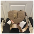 Detailed close-up of heart-shaped lychee texture bag with gold turn-lock and wide strap - Khaki