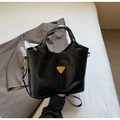 Dettaglio della borsa in pelle cerata nera con logo a triangolo dorato e finiture - Nero