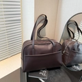 Bolso tote grande y minimalista de cuero marrón oscuro con asas en un ambiente acogedor - Marrón