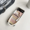 Detalle de funda de tweed para móvil plegable con correa de perlas y dije de oso - Samsung ZFlip3 / Rosa Tejido