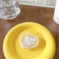 Macro shot of heart-shaped phone grip with marble texture and silver frame on yellow tray - White (Mica Pattern)