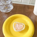 Pink heart phone grip accessory on yellow plate with matte white frame detail - Pink