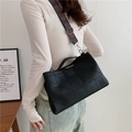 Black geometric patchwork shoulder bag with a colorful woven wide strap on model - Black