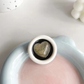 Detail of a round heart-pattern phone socket with gold texture on a pastel tray - Round Drip Glue Gold Silk Heart