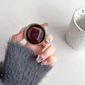Dettaglio dell'impugnatura rotonda per telefono con gemma rosso scuro e perline dorate - Anello Dorato Geometrico Rosso Vino