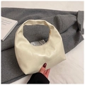 Detail der cremefarbenen Tasche mit geometrischen Nähten und stilvollem Hobo-Design - Gebrochenes Weiß