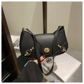 Detail of vintage black crescent bag featuring gold rivets and classic twist lock closure - Black
