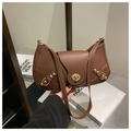 Detail of vintage brown shoulder bag with golden rivet accents and twist lock closure - Coffee