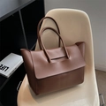 Minimalist large capacity dark brown leather tote bag with flap closure on a white chair - Coffee