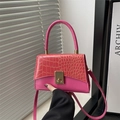 Chic magenta handbag with crocodile pattern flap and golden twist lock on clean background - Pink