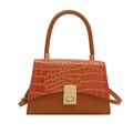 Orangebraune Handtasche mit Krokodilprägung und goldener Schließe auf weißem Hintergrund - Braun