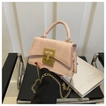 Close-up of pink suede crossbody bag with gold lock and chain strap detail - Pink