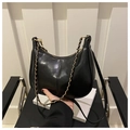 Detail of black semi-circle underarm bag with gold chain strap and polished leather finish - Black