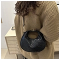 Model wearing black woven hobo crescent bag with polished finish and metal buckle - Black