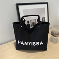 Schwarze Canvas-Tragetasche mit FANYISSA-Aufdruck auf einem minimalistischen Holztisch - Schwarz