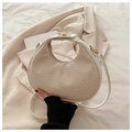 Detalle de bolso medialuna blanco con textura de cocodrilo y cremallera dorada en beige - Blanco