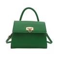 Green leather handbag with gold twist lock and adjustable shoulder strap on white background - Green
