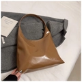 Vista detallada del bolso hobo de charol marrón brillante sobre un abrigo gris texturizado - Marrón