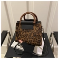 Detail of leopard print tote bag featuring brown resin ring handle and black leather flap - Brown