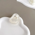 Detalle de soporte para móvil blanco crema con flor 3D y perlas sobre una bandeja - Rosa Ojo de Gato