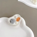 Dettaglio di perla, sfera di marmo e rilievo di rosa su un supporto per cellulare vintage - Rosa Rendering Grigio