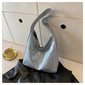 Detail der silbernen Metallic-Tasche mit Patchwork-Struktur auf schwarzer Lederjacke - Silber