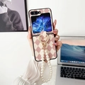 Detalle de funda plegable rosa de rombos con soporte de anillo dorado y correa de perlas - Argyle Rosa con Anillo de Diamantes y Cadena de Perlas / Samsung ZFlip3