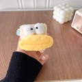 Macro dettagliata della custodia per auricolari in peluche con design morbido e divertente - Stile Bocca Grande Crema