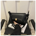 Detalle de bolso de cuero negro con hebilla dorada mate y correa con nudos decorativos - Negro