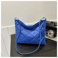 Détail d'un sac fourre-tout bleu roi matelassé avec surpiqûres losanges sur bois - Bleu